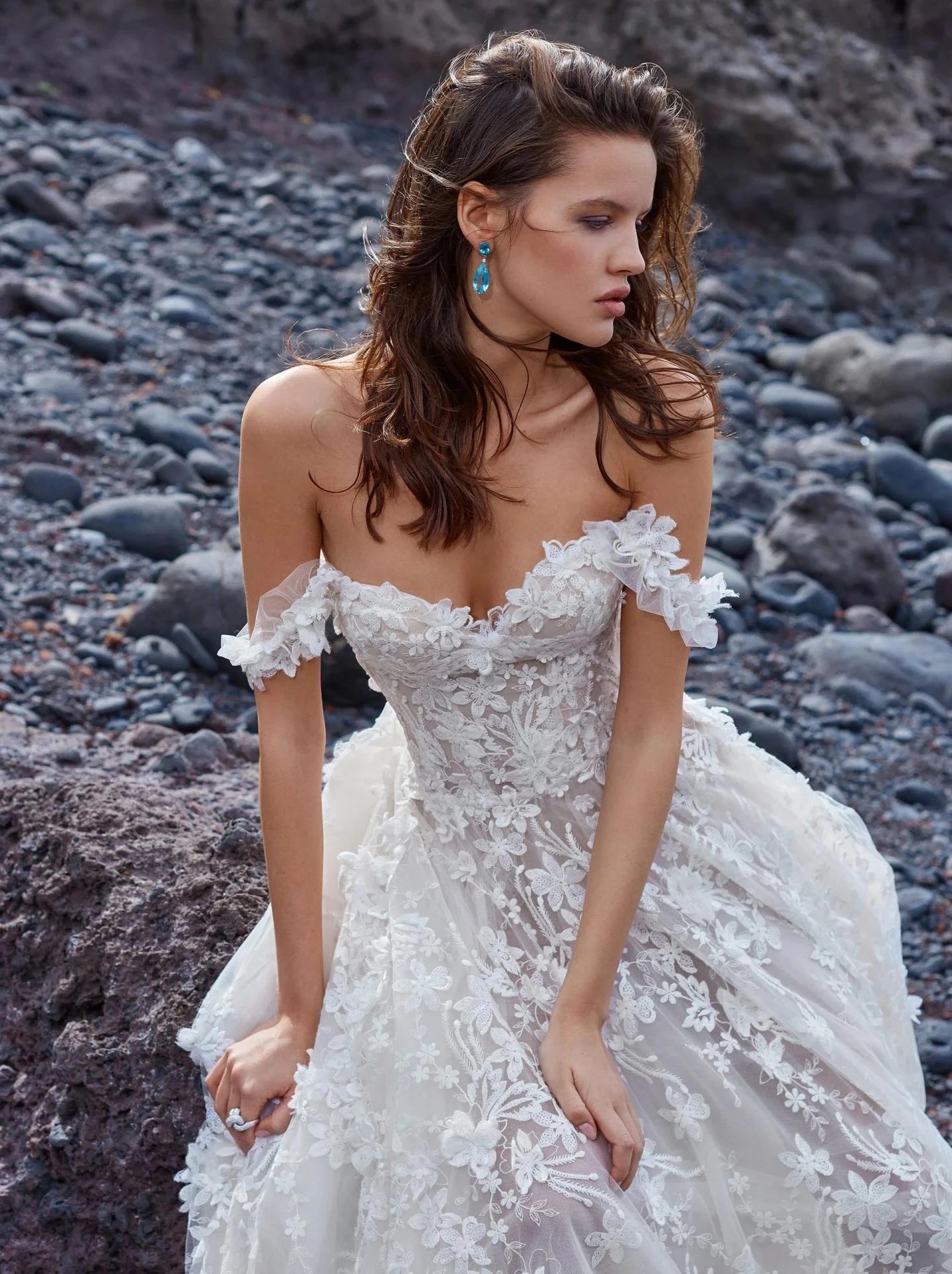 Indulge in luxury with our Robe Appoline, the perfect off-shoulder wedding dress for a beach destination. Made with high-quality lace, this vestido de novia exudes elegance and sophistication. Feel like a goddess on your special day with this exclusive piece.