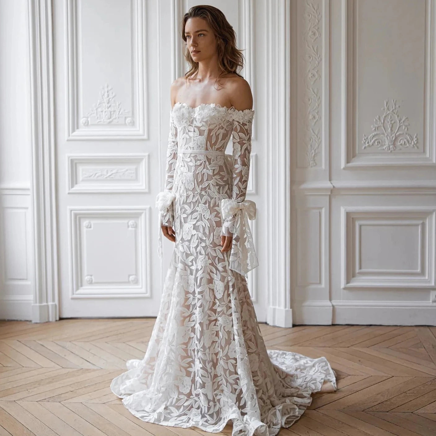 Elevate your special day with the Robe Alana. This exquisite lace mermaid wedding dress boasts an off the shoulder sweetheart neckline and detachable sleeves for an elegant, customizable look. Its long silhouette is designed to stun and captivate, making you feel like a true work of art.