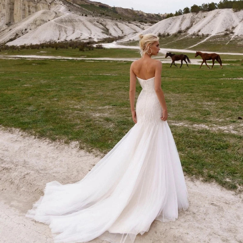 Elevate your wedding day with the grace and beauty of our Robe Finetta. Crafted with a strapless sweetheart neckline and mermaid silhouette, this dress adds a touch of elegance to your special day. The intricate sequin detailing and beachy vibes make it the perfect choice for a seaside celebration.