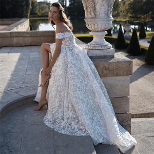 Be the standout bride in our Robe Dominique! This luxury floral embroidered wedding dress features an off-shoulder neckline and is custom made for the perfect fit. Plus, it comes with a removable feature for versatility. Say "I do" in style with our unique and elegant robe!