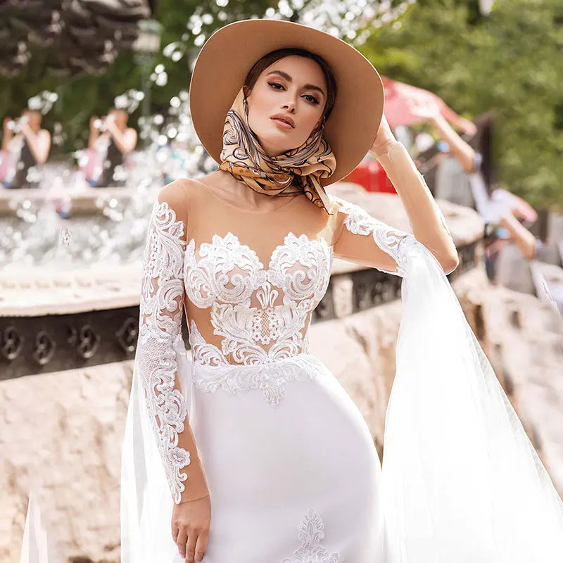 Introducing the Robe Lunete - a boho mermaid wedding dress that will make you feel like a mermaid queen! Featuring delicate lace appliques, illusion tulle, and stylish long sleeves, this dress is the perfect choice for a bride looking for a unique and stunning look on her special day. The shawl adds an extra touch of elegance and can be styled in multiple ways. Say yes to this button-up beauty!