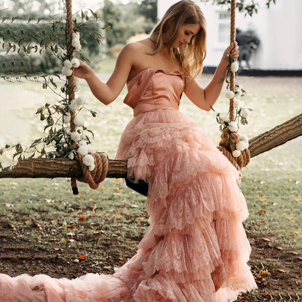 Elevate your wedding day in the exquisite off shoulder Robe Melissa. Crafted with delicate tiered lace in a dreamy mauve pink hue, this A-line custom-made gown is perfect for the plus-size bride. With a breathtaking long train and tutu details, this dress is a must-have for your elopement photoshoot.