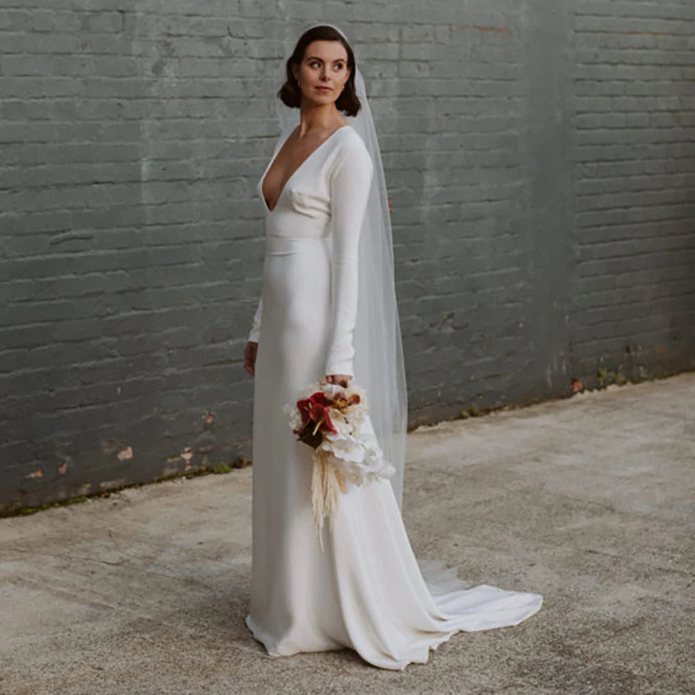 Robe Zelie is a one-of-a-kind custom made bridal gown. Featuring a luxe deep V-neckline, long fitted sleeves, and an A-line crepe skirt with a closed back zipper, this elegant wedding dress is perfect for plus size brides. The perfect balance of style and comfort, Robe Zelie is a sure show-stopper.