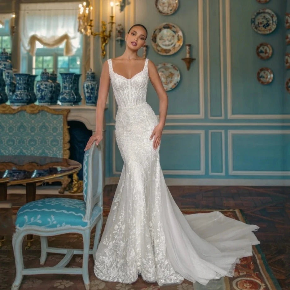 Indulge in sophistication and elegance with our exquisite Robe Fabienne. This square-neck A-line wedding dress features intricate lace appliques and sparkling sequins, exuding the charm and grace of a true bride. Crafted with luxurious tulle, the sweep train adds a touch of romance to this stunning gown.