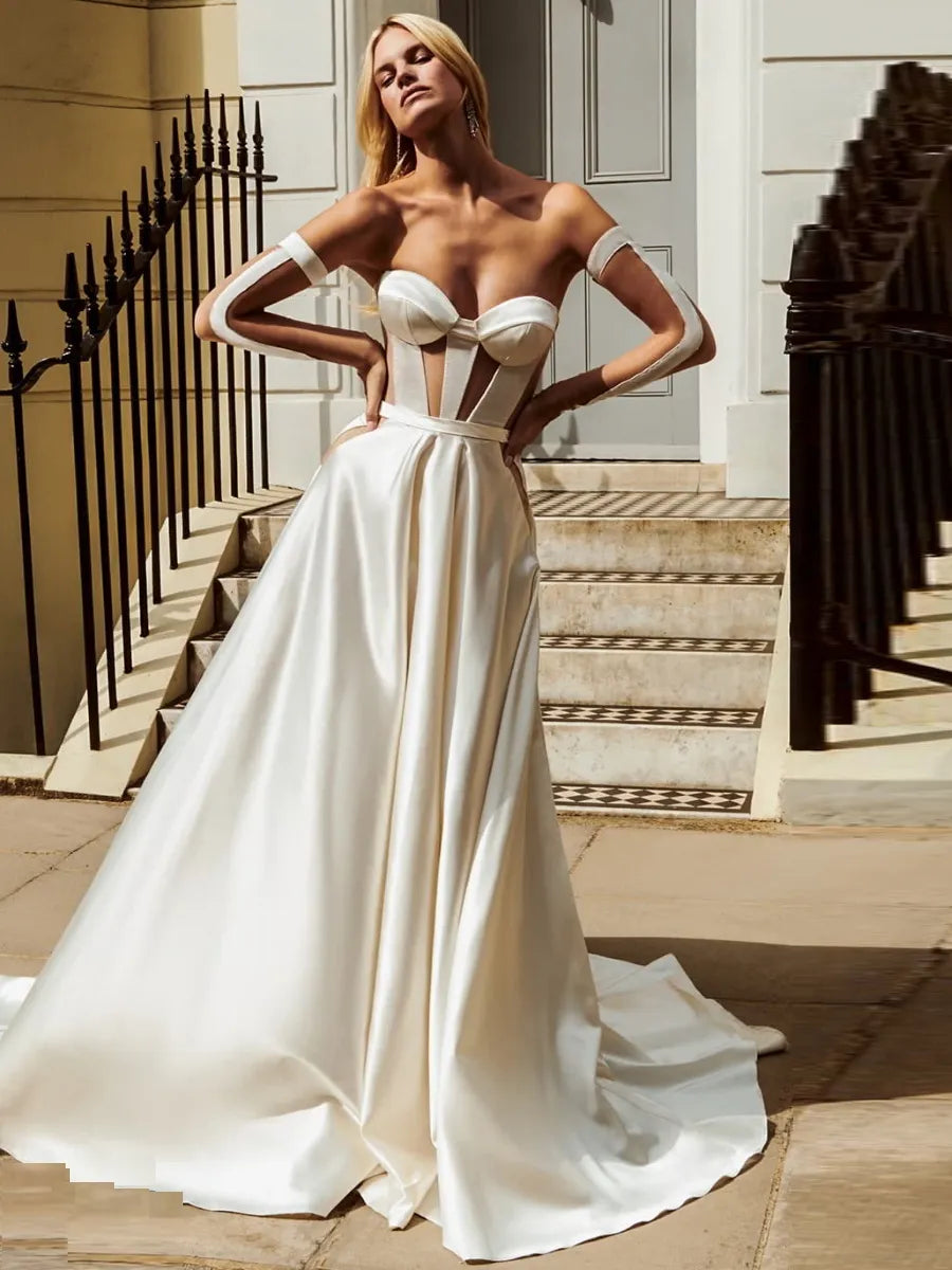 The Robe Nika is an elegant bridal gown, perfect for the modern minimalist bride. The strapless sweetheart neckline, A-line ball gown shape, and detached sleeves create a timeless look that will gracefully flatter any body type.