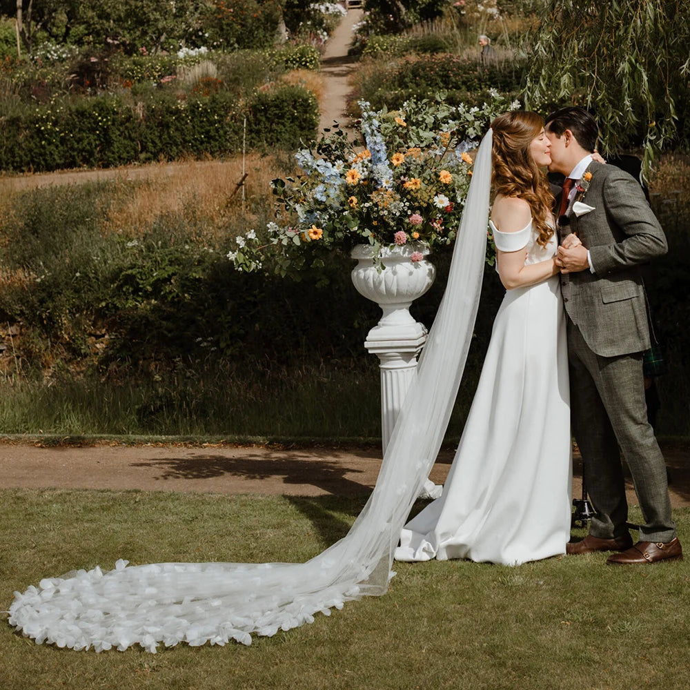 Indulge in the romance of a fairytale wedding with the Bloom Flowers Romantic Wedding Dress Michelle. This custom-made off-white mesh veil comes with a delicate blusher that adds elegance to your bridal look. The comb headpiece adds a touch of glamour and compliments your beauty on your special day.