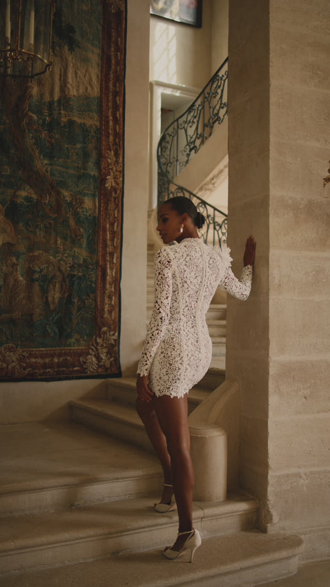 Glamourous two-piece combination in ivory color. Featuring a white intricate floral lace long-sleeved turtleneck mini dress adorned with 3D flowers and an elegant fitted satin skirt with a daring thigh slit. Take off a skirt when you are ready to hit the dancefloor. This combination can be easily worn long after your wedding as two separate wardrobe items.